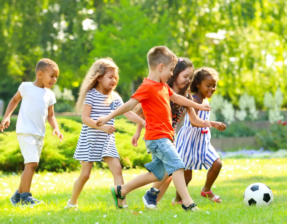 Children playing soccer outside.