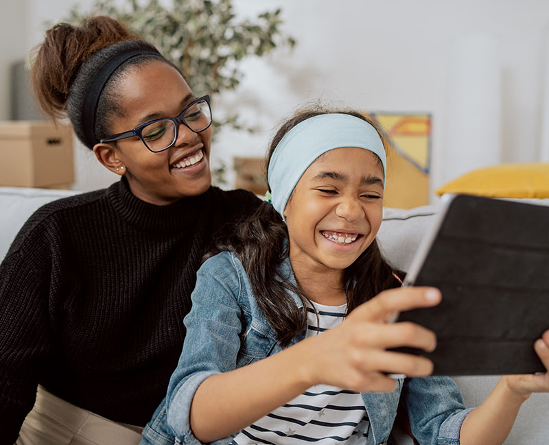 mother and daughter watching video on the tablet