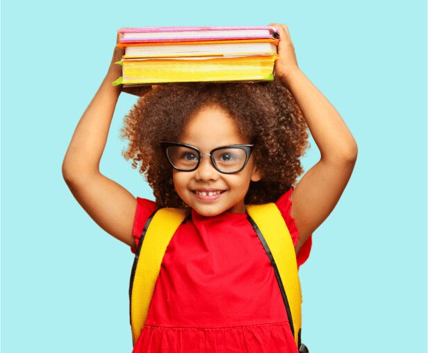 child with eyeglasses carrying books at VisionQuest