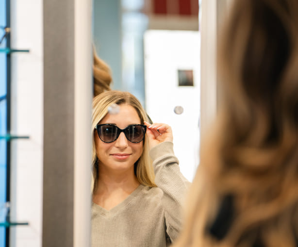 stylish woman wearing red framed sunglasses at VisionQuest Eyecare
